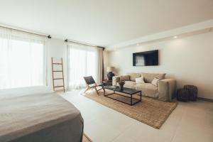 sypialnia z łóżkiem, kanapą i stołem w obiekcie Cala Lanuza Suites w mieście El Campello