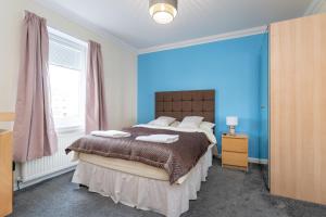 a bedroom with a bed and a blue wall at NEW Four Bedroom House - all rooms ensuite in Stirling