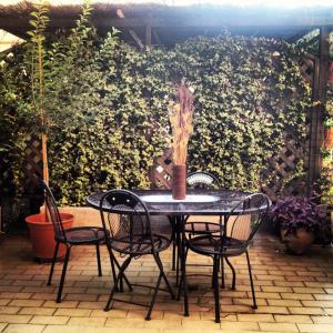 una mesa de patio con sillas y una planta en B&B Borgomarino, en Pescara