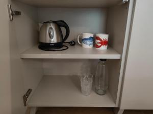 a tea kettle and two cups on a shelf at Agriturismo Resort Il Foionco in Massa Marittima