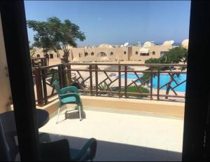 een kamer met een balkon met uitzicht op een zwembad bij Pool view one bedroom - B203 in Hurghada
