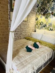a bed with two pairs of slippers on top of it at Lovely 1-bedroom studio in the heart of Old Part of Termini Imerese in Termini Imerese