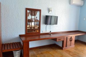 a room with a table with a mirror and a tv at Serene Beach Resort in Dar es Salaam