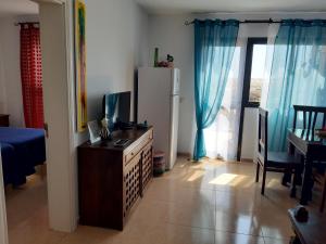 cocina con cómoda y nevera en una habitación en Casa Vacanza in Oasis Tamarindo, en Corralejo