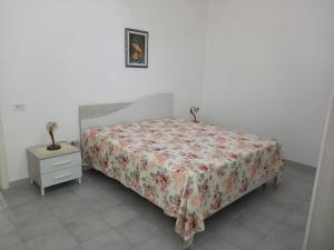 um quarto com uma cama e uma cómoda com uma colcha em Casa Giada em Porto Cesareo