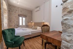 a bedroom with a bed and a table and a chair at Residence Providenca in Trogir