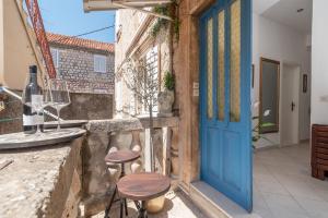 a porch with two stools and a blue door at Residence Providenca in Trogir