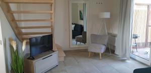 a living room with a flat screen tv and a staircase at Apatramenty Gaga Dębki in Dębki