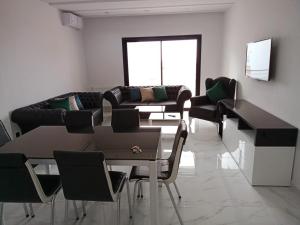 a living room with a couch and a table and chairs at Superbe Appartement in Sousse