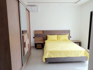 a bedroom with a bed with a yellow bedspread at Superbe Appartement in Sousse