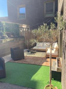 a garden with a patio with a tree and a couch at Pet Friendly 1 Bedroom Apartment in London Fields in London
