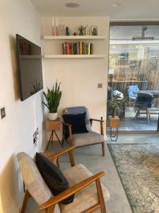 a living room with two chairs and a tv at Pet Friendly 1 Bedroom Apartment in London Fields in London
