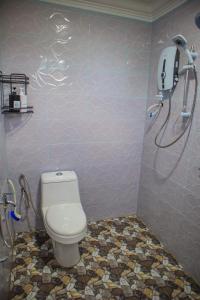 a bathroom with a toilet and a shower at GM Roomstay Kuala Besut in Kampong Gong Manok