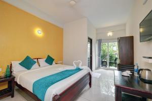 Kurinji Wanderlust Resort Munnar في مونار: غرفة نوم بسرير كبير ونافذة كبيرة