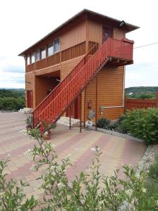 a wooden house with a staircase in front of it at Rózsapark Panoráma-apartman - maximum 4 fő részére in Demjén