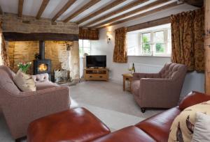 een woonkamer met 2 stoelen en een open haard bij The Nook in Guiting Power