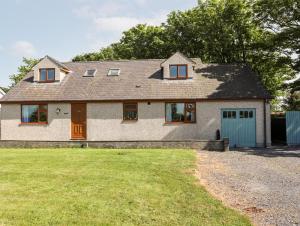 a house with a blue door and a yard at Bryncoed in Holyhead