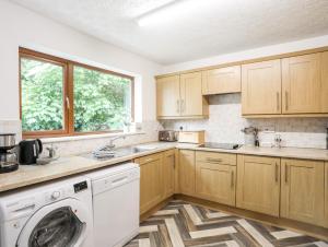 a kitchen with a washing machine and a window at Bryncoed in Holyhead