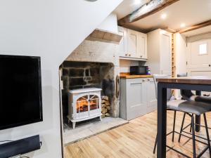 a kitchen with a fireplace in the middle of a room at 2A Chiserley Stile in Hebden Bridge