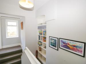 een trap in een huis met twee ingelijste boekenplanken bij Yewbarrow Cottage in Grange Over Sands