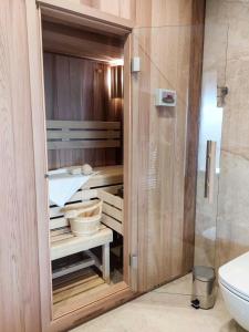 a bathroom with a wooden closet with a sink and a toilet at Wellness chalet Vénus in Liptovský Mikuláš