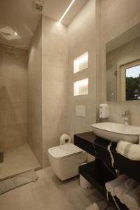 a bathroom with a toilet and a sink and a tub at KOMPLEKSI ROYAL in Velipojë +60 photos