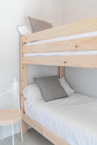 two bunk beds in a room with a chair and a table at BAO 1 / APARTAMENTO CON JARDÍN in Somo