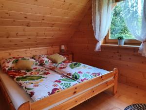 A bed or beds in a room at Borowikowe Zacisze drewniane domy z dostępem do balii i sauny