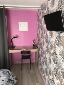 biurko w sypialni z fioletową ścianą w obiekcie Agréable Maison au calme w mieście Périgueux