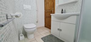 Baño blanco con aseo y lavamanos en Palazzotto la Volta - Tricase, en Tricase