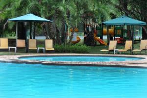 a swimming pool with chairs and umbrellas and a playground at Legend Safaris 257A - in Kruger Park Lodge in Hazyview