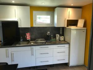 a kitchen with white cabinets and a sink at Agréable Maison au calme in Périgueux