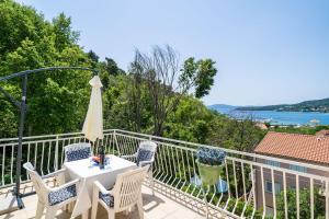 a patio with a table and chairs on a balcony at Apartments Villa Cerjak in Slano