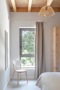 a bedroom with a chair and a window at BAO 1 / APARTAMENTO CON JARDÍN in Somo