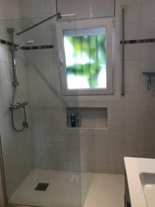 a bathroom with a shower with a window and a sink at 'Casa Empuria' aan kanaal met zwembad en aanlegsteiger in Empuriabrava