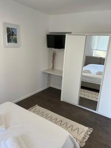 a white bedroom with a mirror and a bed at Mozgan Apartments in Piran