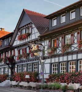 un edificio con mesas y sillas delante de él en Hotel Restaurant Der Engel, Sasbachwalden, en Sasbachwalden