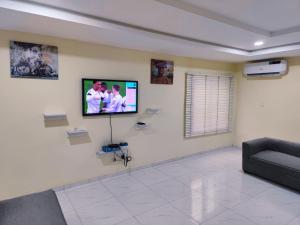 a living room with a flat screen tv on a wall at The Shelter in Garki