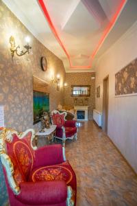 een woonkamer met rode stoelen en een bank bij HOTEl MKUDRO in Koetaisi