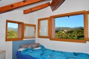 1 dormitorio con 3 ventanas y 1 cama. en VARDIOLA/PORTO VECCHIO, en Pinarellu