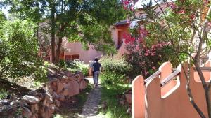 Una mujer caminando por un camino delante de una casa en VARDIOLA/PORTO VECCHIO, en Pinarellu