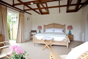 a bedroom with a large bed and a table at The Old Hop Kiln Barn in Petersfield