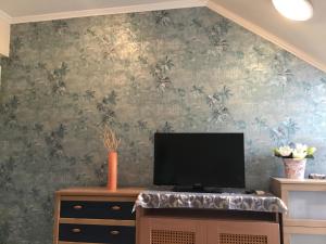 sala de estar con TV en la pared en Family Wellness Apartman en Hajdúszoboszló