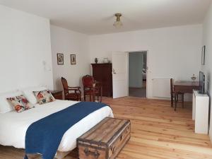 1 dormitorio con 1 cama, mesa y sillas en l'Airial de Larroque, en Soustons