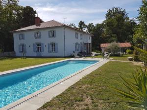 a house and a swimming pool in front of a house at l'Airial de Larroque in Soustons