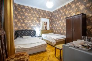 een slaapkamer met 2 bedden en een dressoir. bij HOTEl MKUDRO in Koetaisi