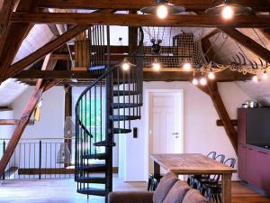 - un escalier en colimaçon dans une chambre avec une table dans l'établissement Igelnest Großthiemig, à Großthiemig