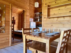 a wooden dining room with a wooden table and chairs at LIDO - domy letniskowe z klimatyzacją in Krynica Morska