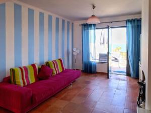 ein Wohnzimmer mit einem roten Sofa und einem Balkon in der Unterkunft Isabel sea view apartment in Albufeira