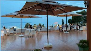 a group of people sitting at tables under umbrellas at Jozi Kaiser Apartment 2 in Durrës